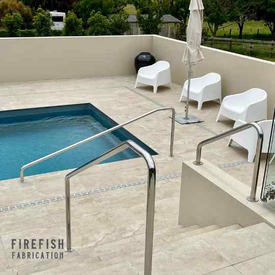 Image of a custom made stainless steel handrails for swimming pool area at a residential home in Auckland. Bespoke fabrication experts, Firefish Fabrication.