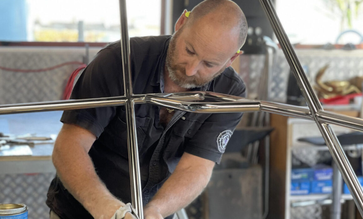 A marine stainless steel fabricator polishing a project before final install. Auckland, NZ. Marine Stainless Steel Fabrication Auckland - stainless polishing of marine boat Bowrail